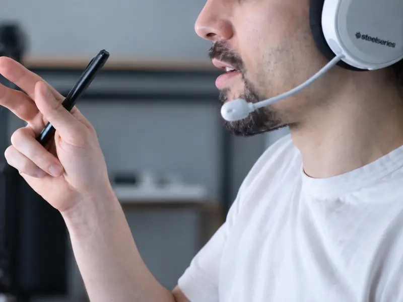 A teacher in a headset explains a point during a live online lesson