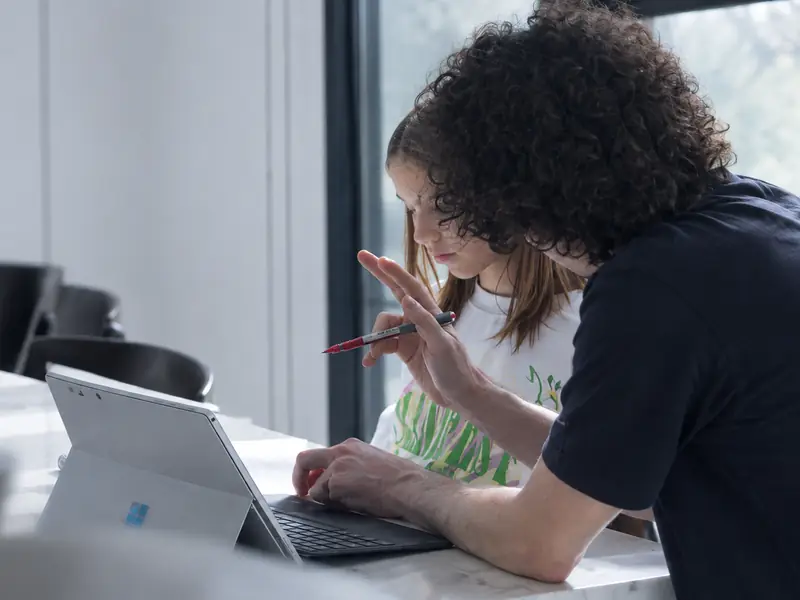 A student explains her working to the teacher beside her