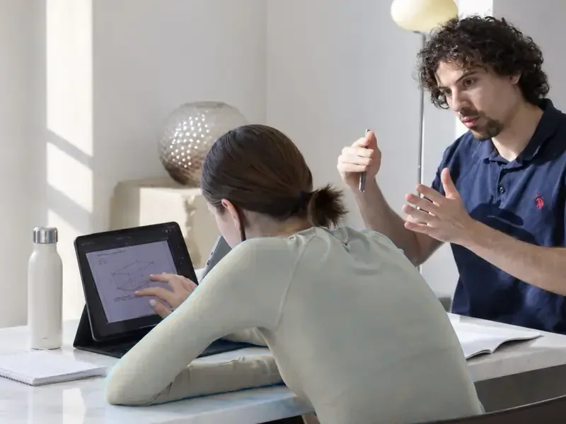 A teacher explains a method while a student follows on a tablet